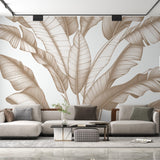 Tropical leaf wallpaper with beige banana leaves creating a calm atmosphere in a modern living room with natural light