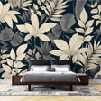 Tropical botanical wallpaper with cream leaves on black background styled in modern living room with minimal furniture