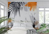 Home office with modern tropical wall mural showing black palm leaves and orange details