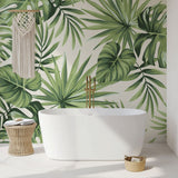 Tropical Monstera leaf wallpaper creating a fresh backdrop in a modern living room with white furniture