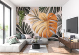 Orange and green monstera wallpaper in home office creating focus wall