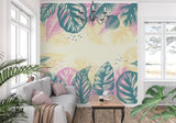 Pink and teal monstera wallpaper brightening up a dining room with natural light