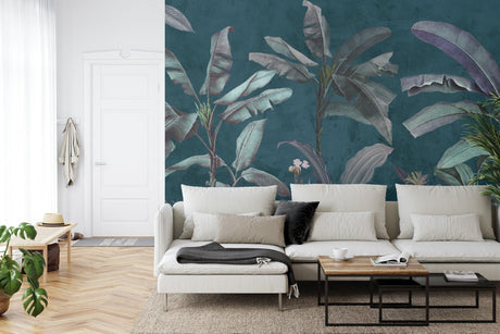 Tropical banana leaf wallpaper creating luxury feel in modern living room with grey sofa and gold accents