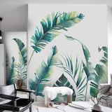 Tropical leaf wallpaper in bright modern living room showing watercolor banana leaves creating airy atmosphere