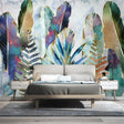 Tropical leaf wallpaper with watercolor feathers and ferns creating a calm atmosphere in a modern living room