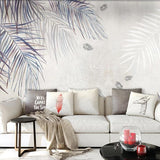 Tropical palm leaf wallpaper in modern living room showing watercolor style fronds in blue-grey tones
