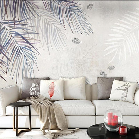 Tropical palm leaf wallpaper in modern living room showing watercolor style fronds in blue-grey tones