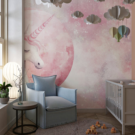 Unicorn wallpaper in a soft pink nursery with white furniture and fairy lights