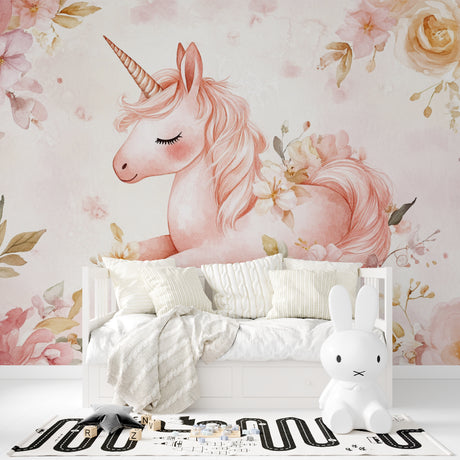 Unicorn wall mural in pink nursery with white furniture showing magical floral design