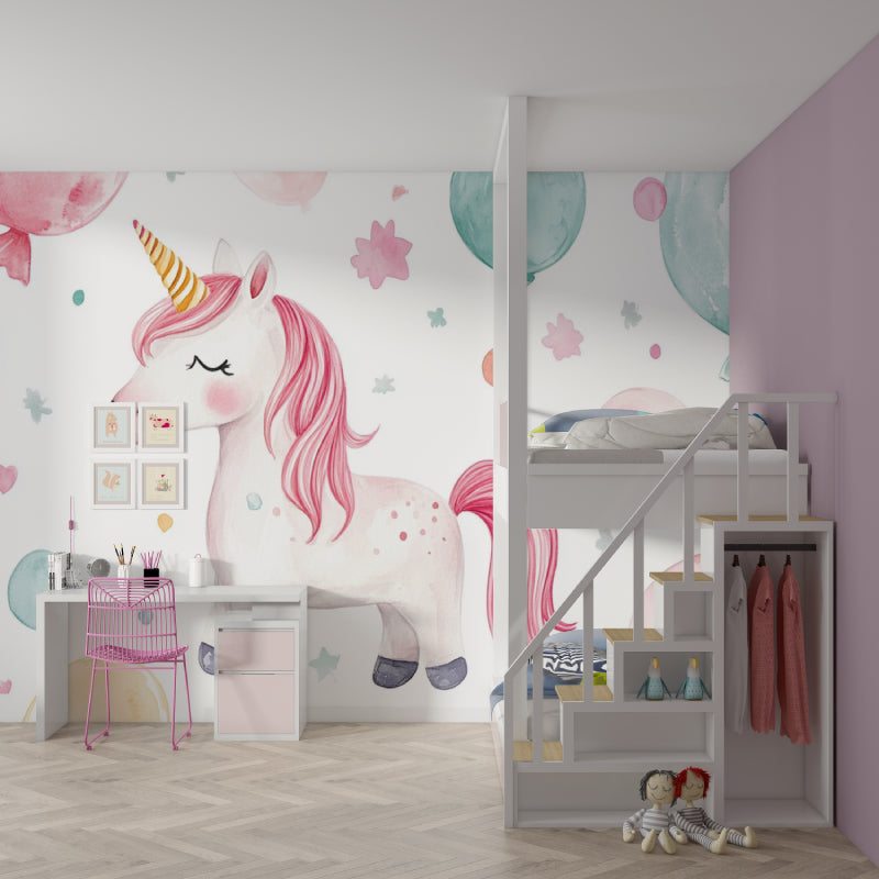 Unicorn wall mural with watercolor balloons brings magic to a bright nursery with white furniture