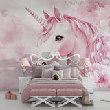 Pink unicorn wall mural in a reading nook with cozy cushions