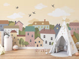 Village wall mural creating a storybook atmosphere in a child's bedroom
