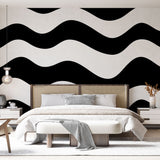 Black and white wave pattern wallpaper showcased in a modern minimalist living room setting
