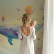 Whale and hot air balloon wallpaper creating magic in a modern nursery with soft lighting and natural decor