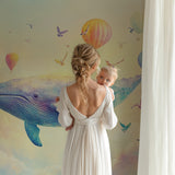 Whale and hot air balloon wallpaper creating magic in a modern nursery with soft lighting and natural decor