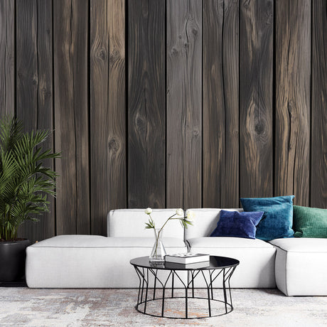 Dark wood plank wallpaper creating a cozy atmosphere in modern living room with grey sofa and natural light
