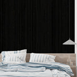 Black vertical wood wallpaper creating dramatic effect in modern dining room
