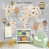 World map wallpaper featured in playroom with toy storage and learning area