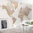 World map wallpaper in a modern home office with natural lighting showing scale and beige tones