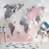Watercolor world map mural brightening up a cozy home office space with soft pink tones